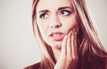 Dental care and toothache. Closeup young woman face worried girl suffering from tooth pain